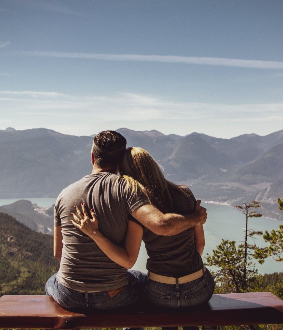 Couples Therapy A man and a woman are sitting on a bench looking at the mountains
