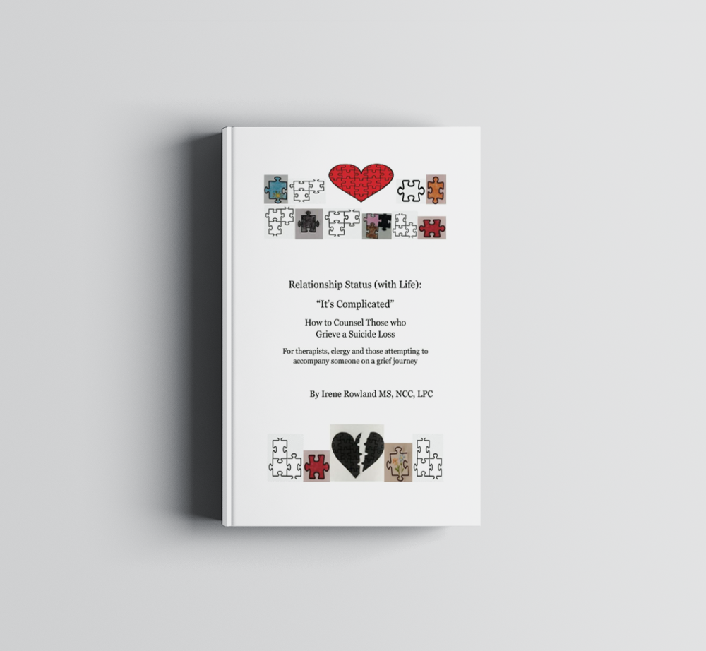 A white book with a red heart on the cover is sitting on a white surface.