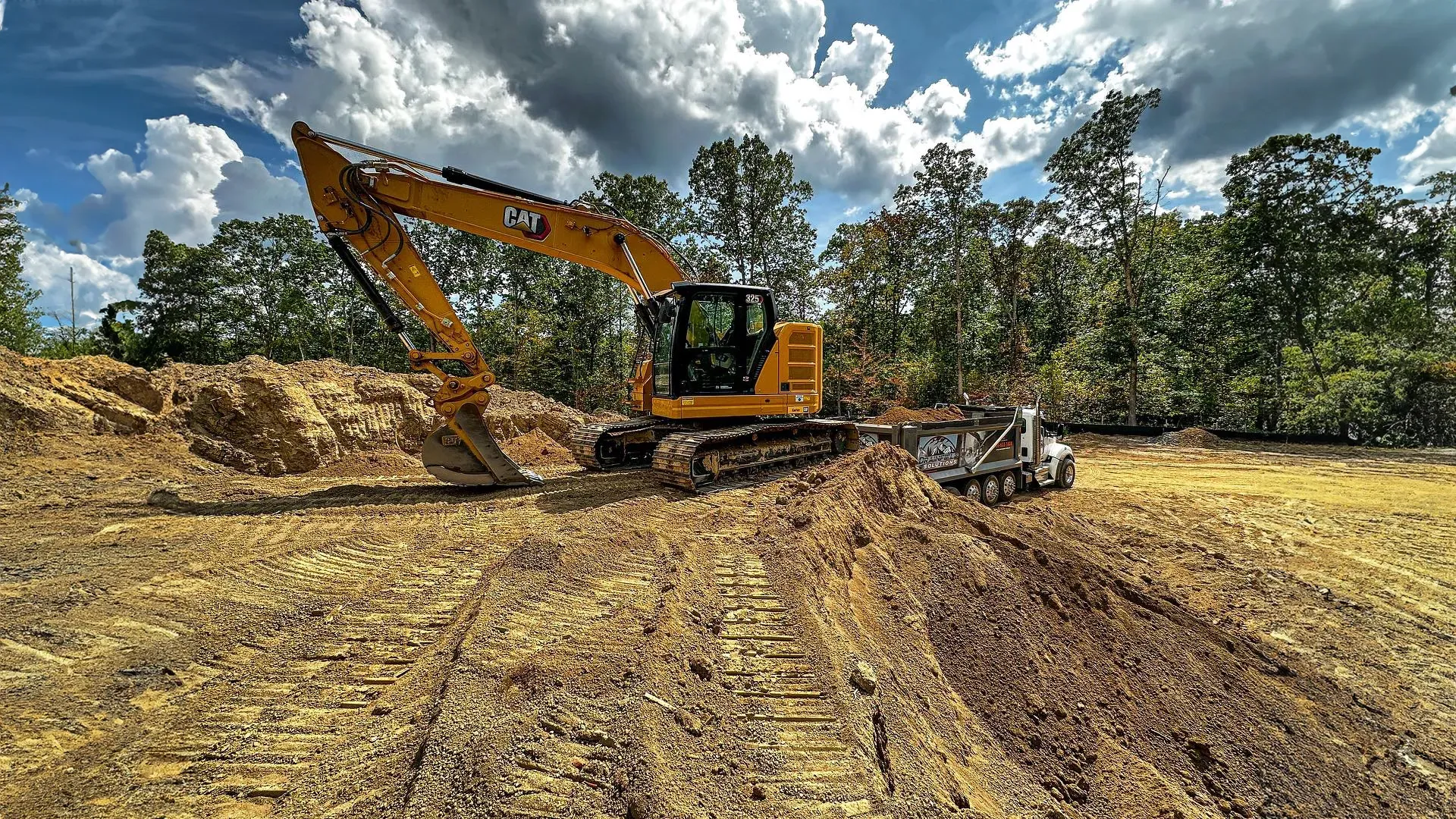 Drainfield Solutions team installing a septic system using large excavation equipment and trucks in 