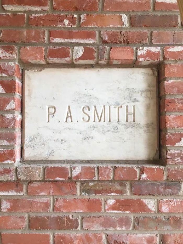 A rectangular, white marble plaque engraved with the name 