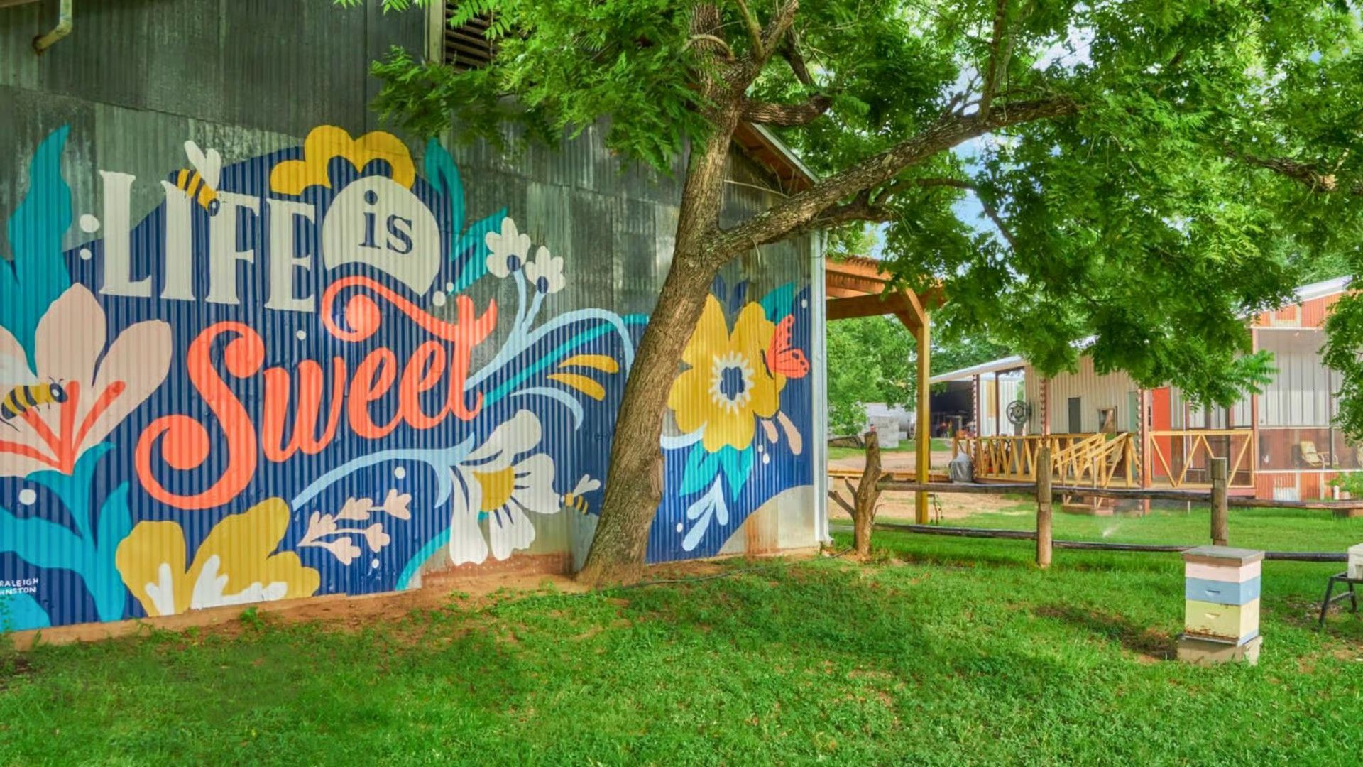 A mural on a metal wall reads 