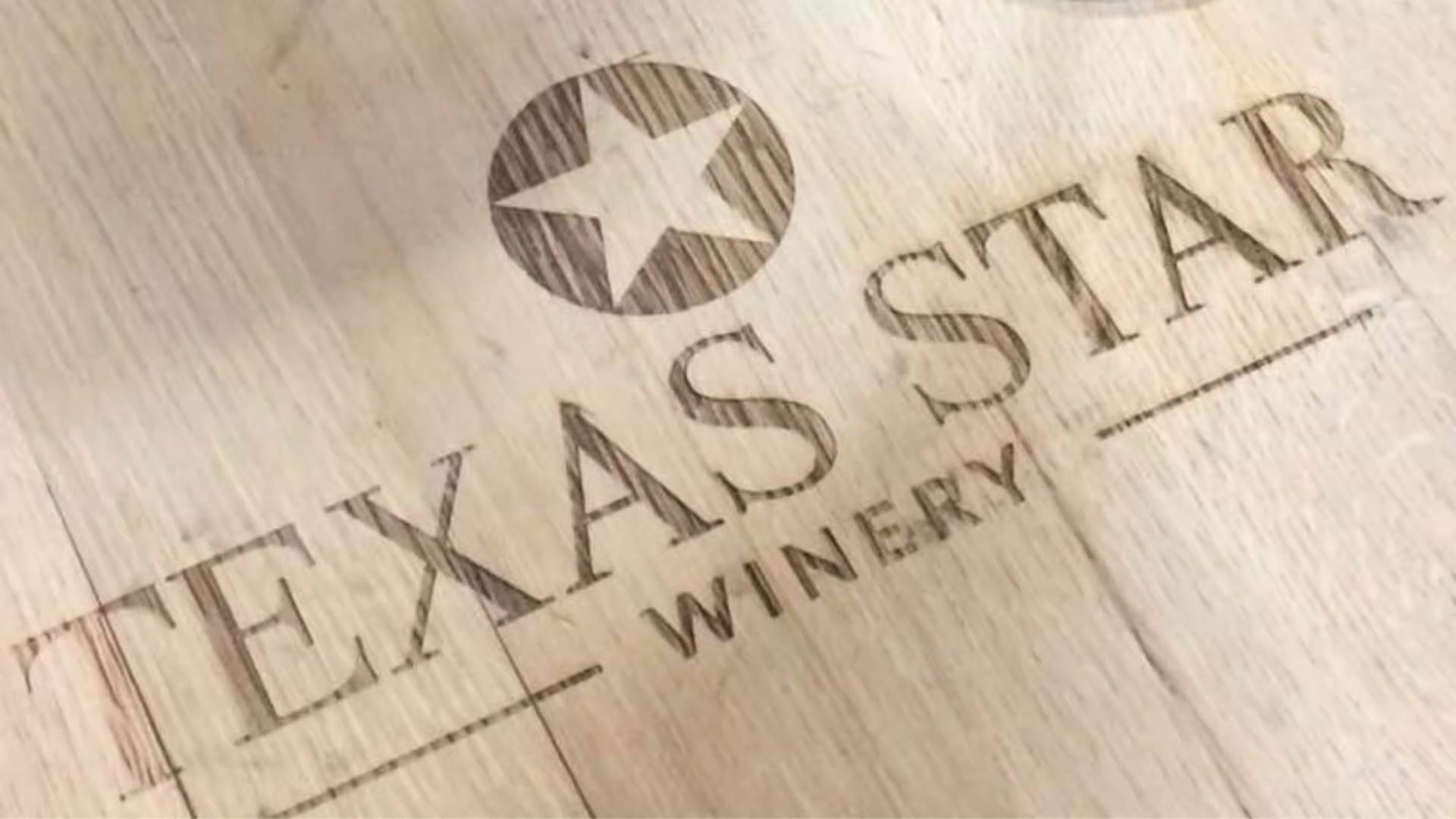 A wood surface engraved with a star icon and the words 
