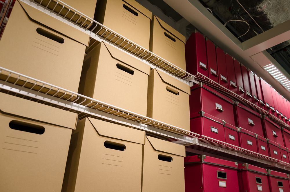 Cardboard and Red Storage Boxes on Metal Shelving — Gympie Mini Storage in Gympie, QLD