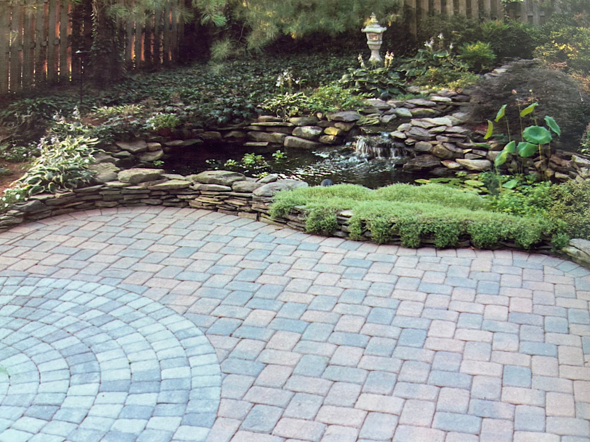 A brick patio with a waterfall in the background