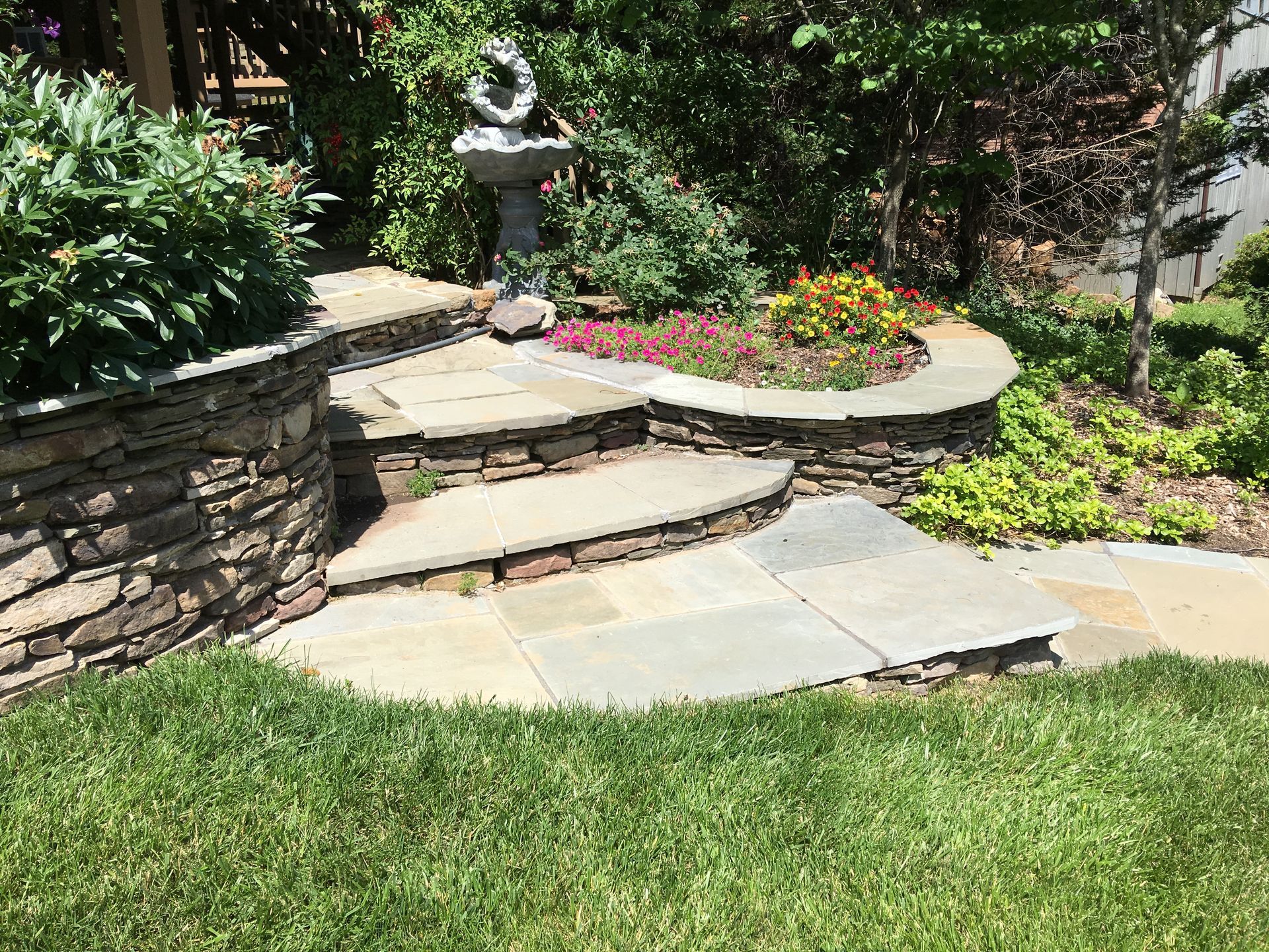 There is a bird bath in the middle of the garden.