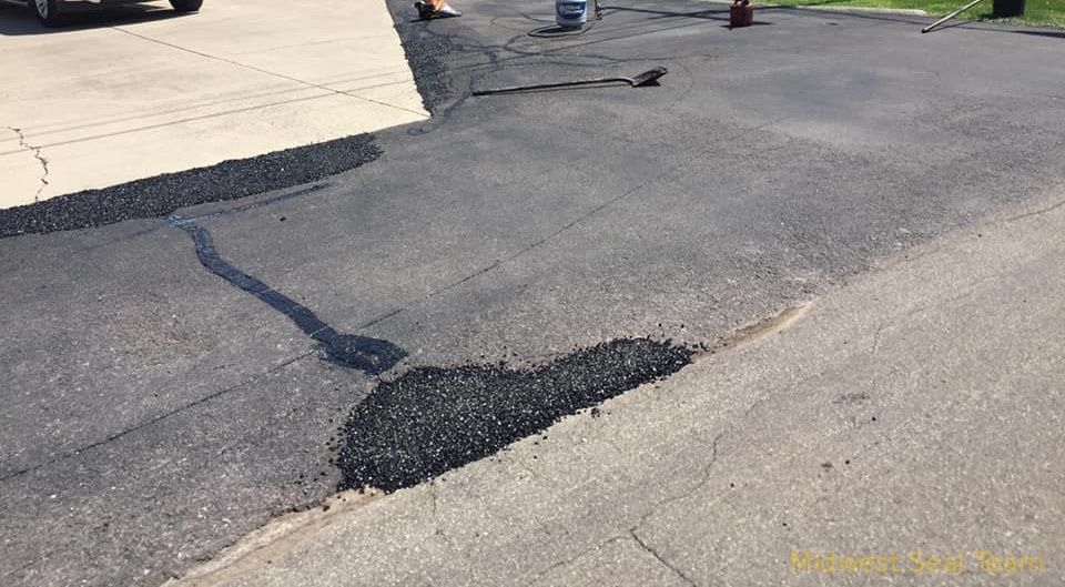 Image showing parking lot painting. You can see a blue handicap parking symbol and white parking lines.