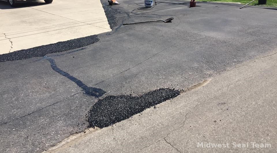 Image showing parking lot painting. You can see a blue handicap parking symbol and white parking lines. 