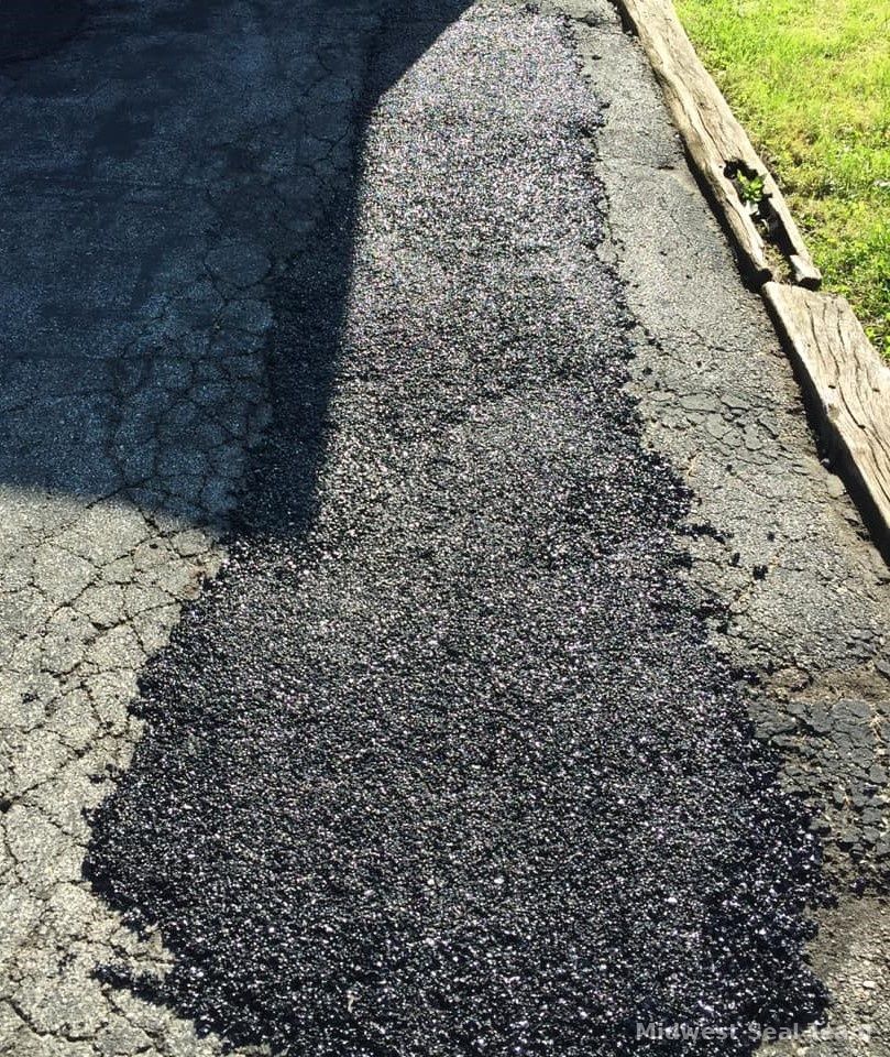 Image of a close up from a road that has been patched up. 