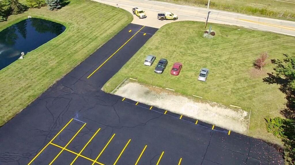 Image showcasing the transformation of a parking lot with pavement marking services provided by the Midwest Seal Team in Fort Wayne, IN.
