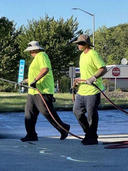 Image of Midwest Seal Team Sealcoating a parking lot. 