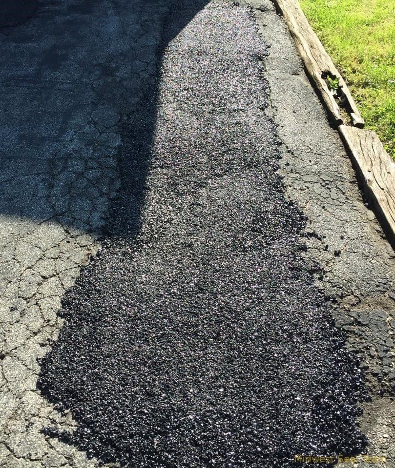 Image of a close up from a road that has been patched up. 