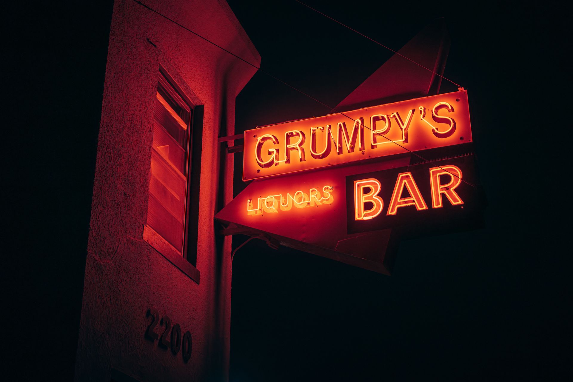 Neon sign glowing outside Grumpy’s Bar in Northeast Minneapolis, a staple of Twin Cities nightlife.