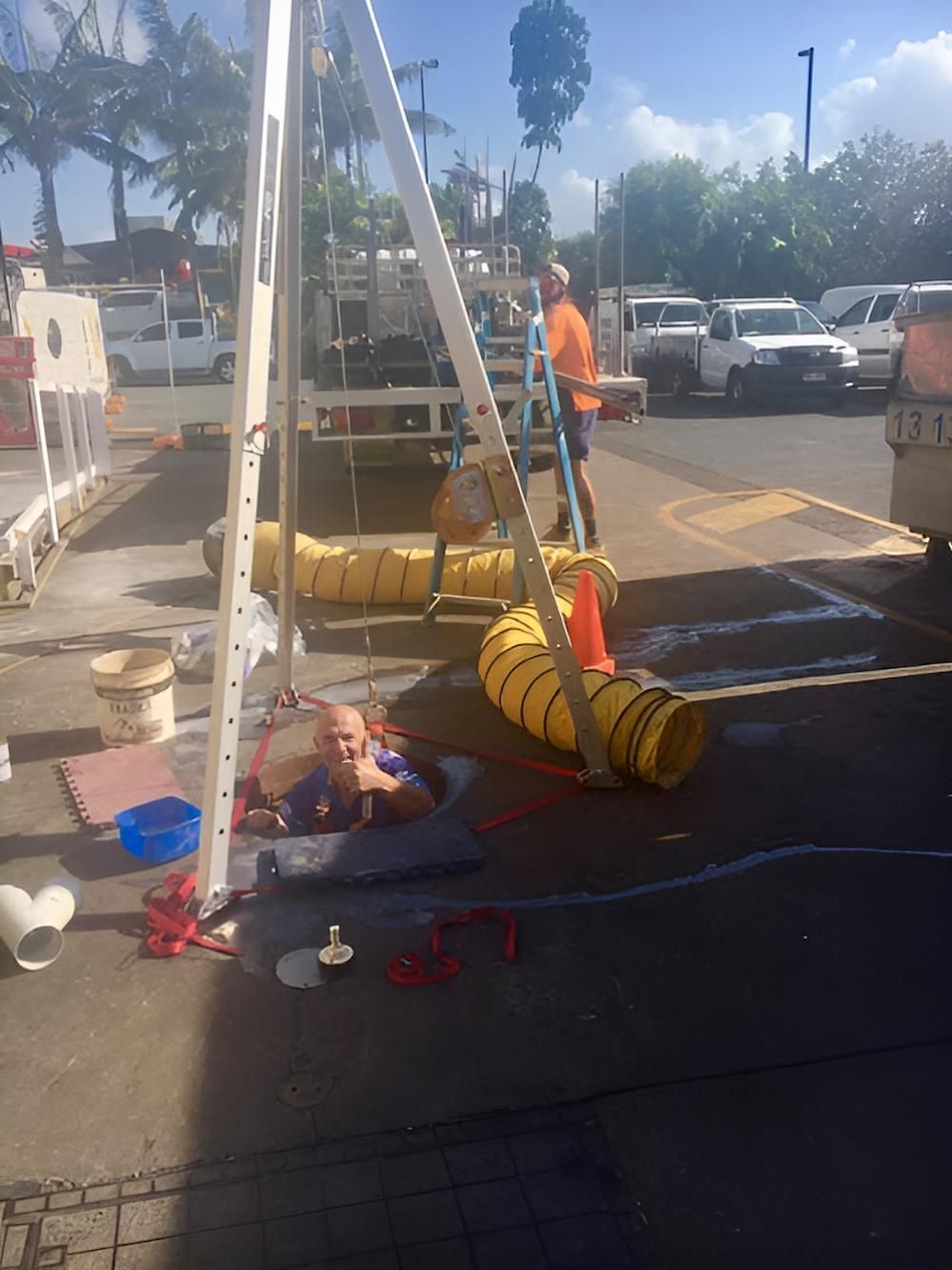A Man Inside the Hole with Big Hose on the Background — De Rose Plumbing In Bayview Heights, QLD