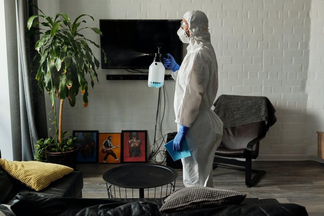 An exterminator spraying insecticide in a home. 