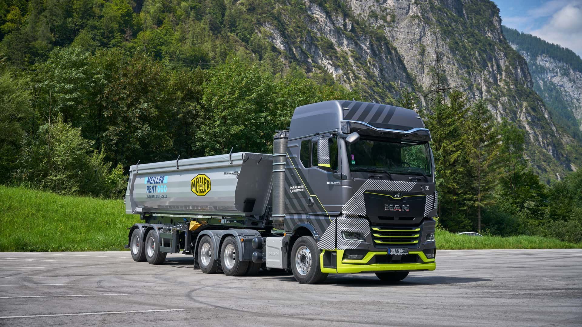 Un semi-remorque est garé sur le bord de la route devant une montagne.