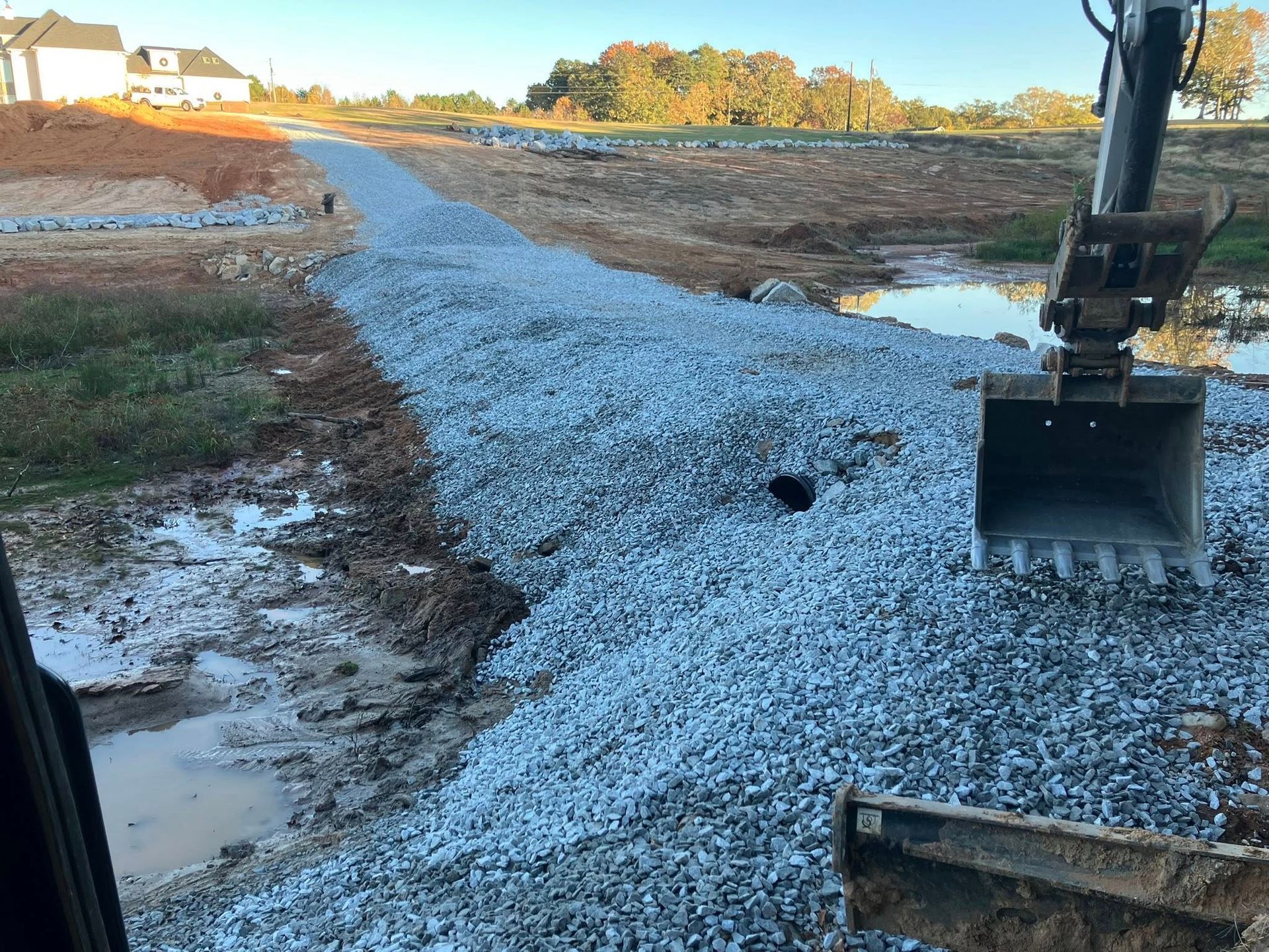 Excavator loading dirt into a dump truck at a construction site.