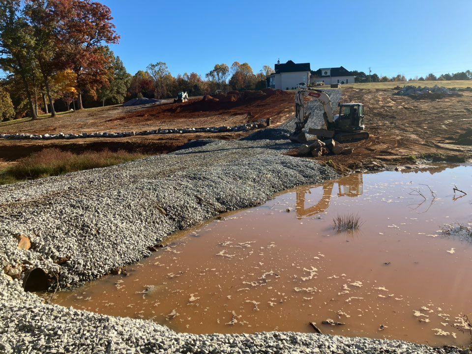 Construction worker pouring concrete with a hose onto rebar-reinforced foundation.