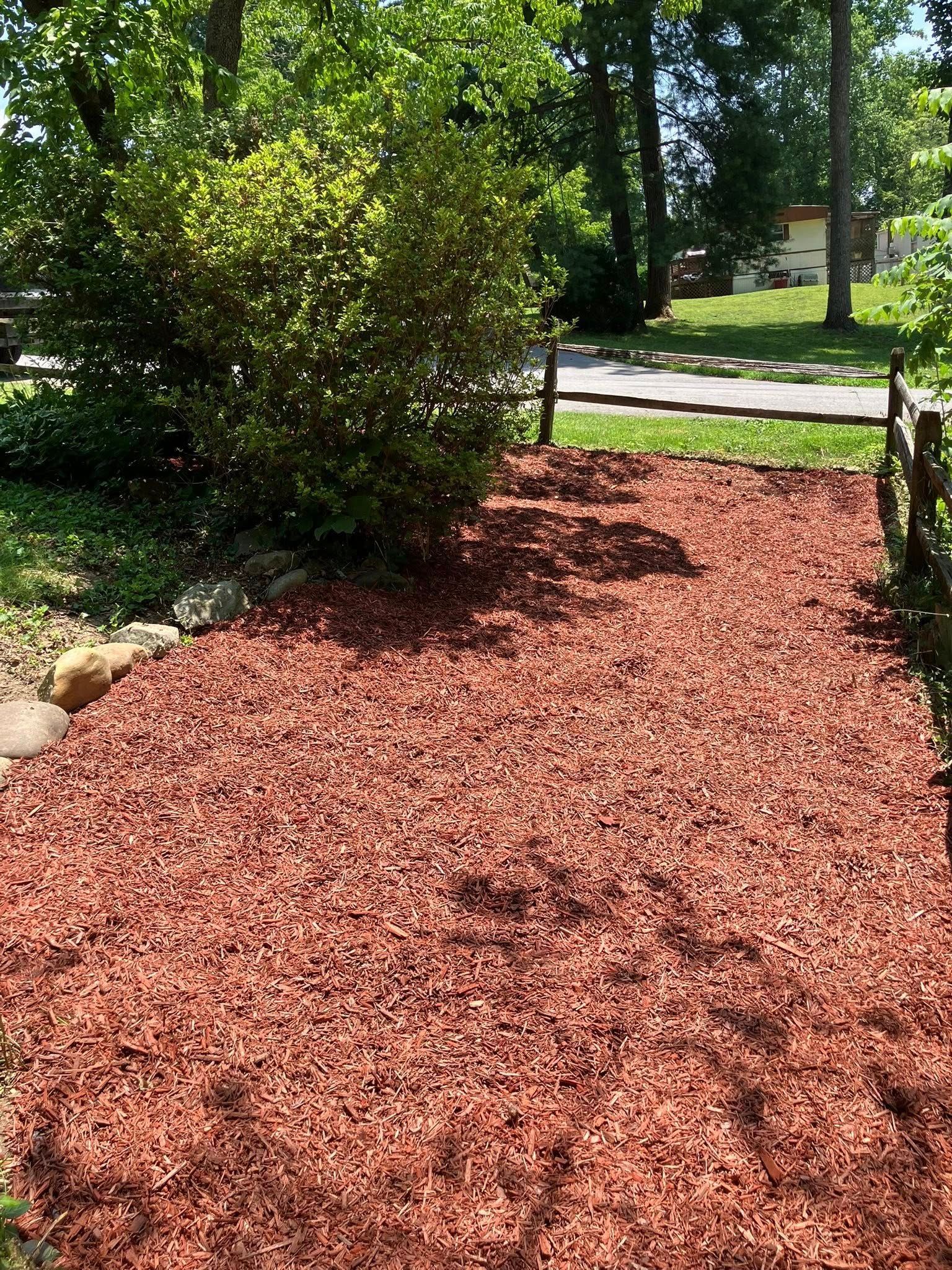 Person installing stone path on grassy ground.