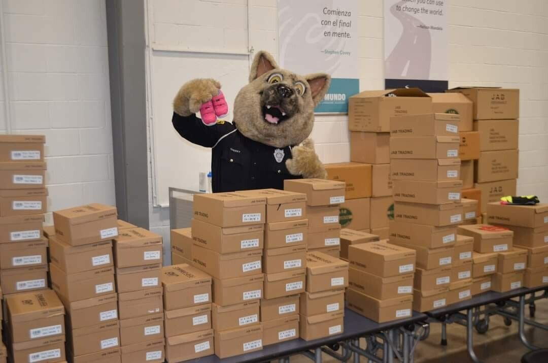 A Mascot Showing a Pair of Shoes