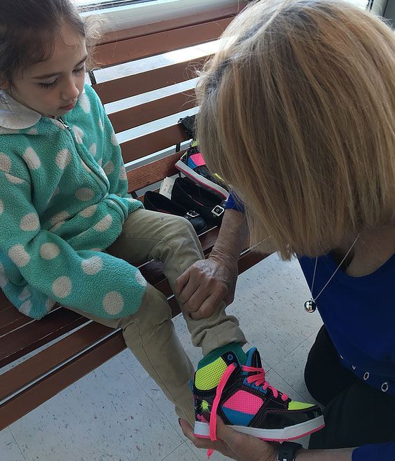 Woman Putting Shoe On Kid