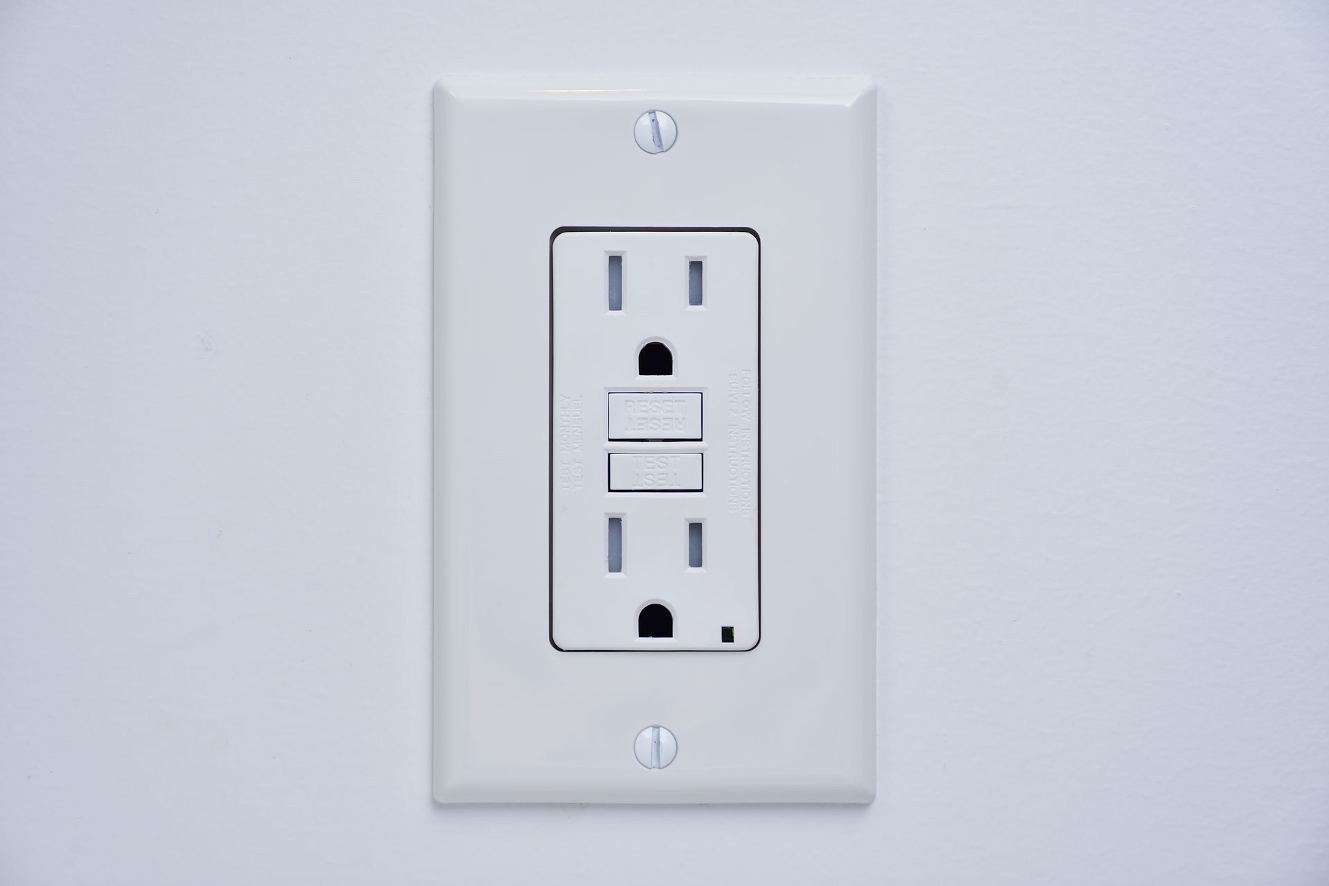 White GFCI electrical outlet on a white wall.
