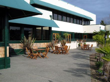 A large building with tables and chairs in front of it