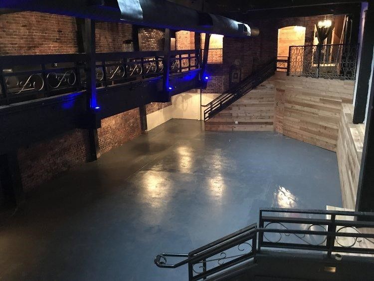 A large empty room with stairs leading up to it.