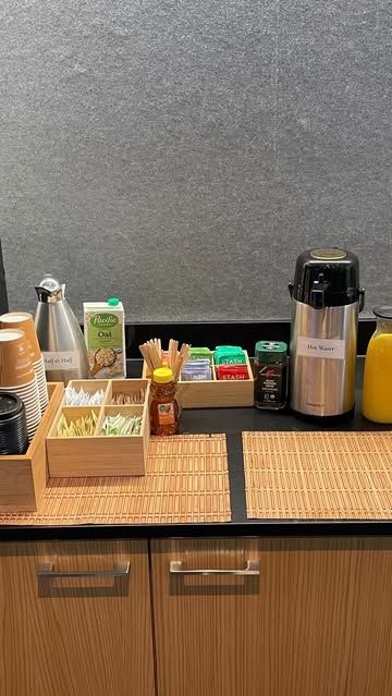 A kitchen counter with a variety of food and drinks on it.