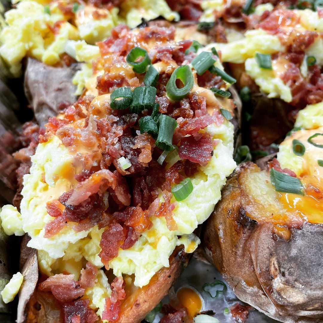 A close up of a plate of food with eggs , bacon and cheese.
