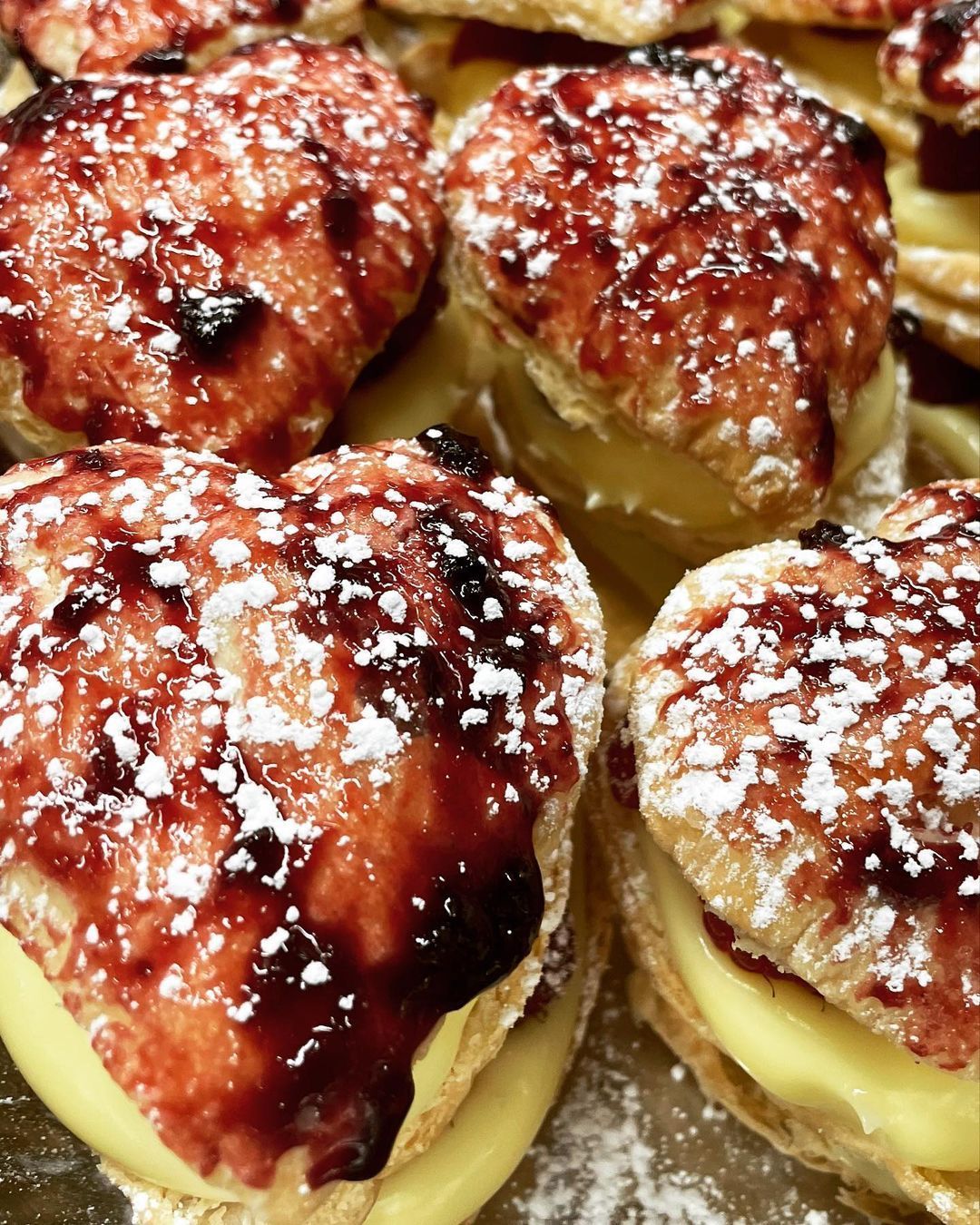 A bunch of heart shaped pastries with powdered sugar on top