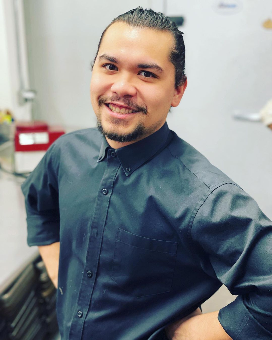 A man in a black shirt is smiling for the camera