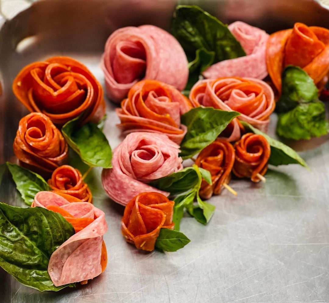 A pan filled with meat roses and spinach leaves