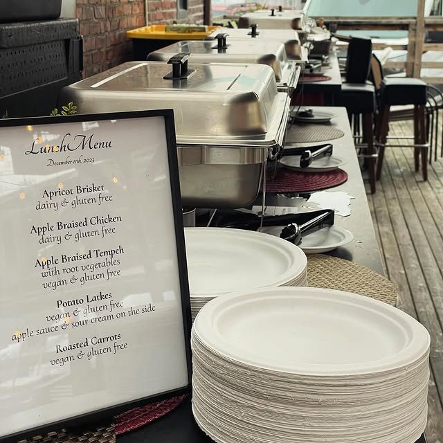 A buffet line with plates and a sign that says lunch menu