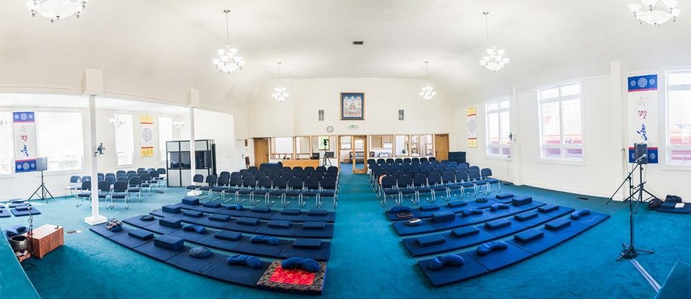 A large room with blue carpet and chairs in it.