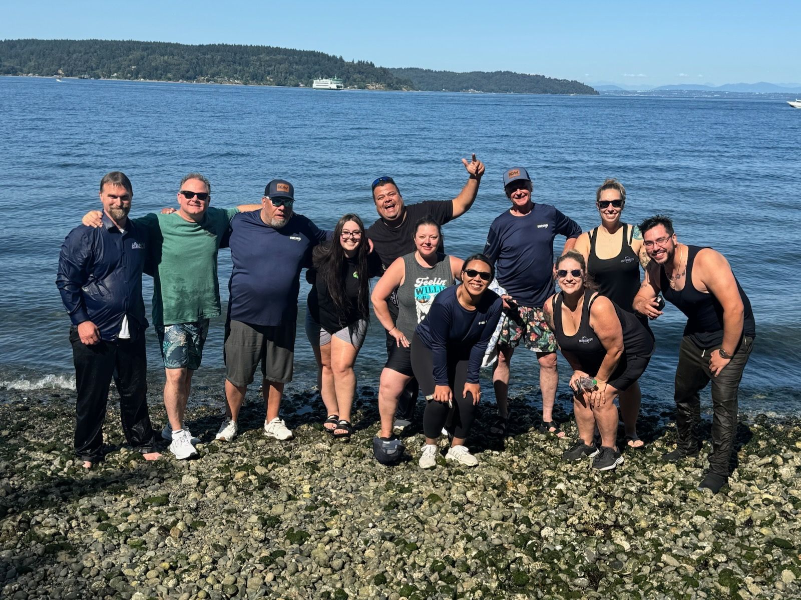 A group of people are posing for a picture on the beach.