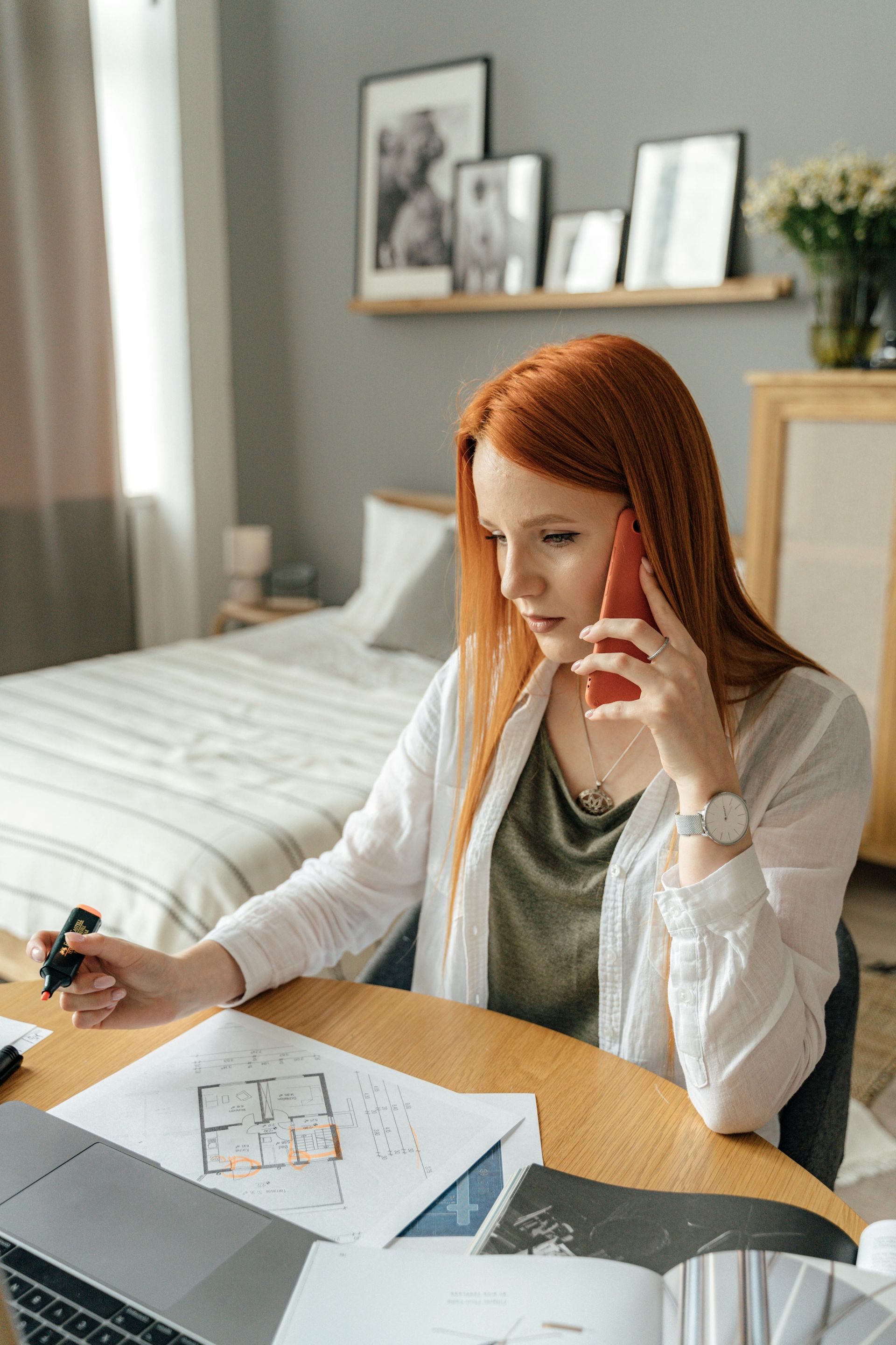 A woman is sitting at a table talking on a cell phone.