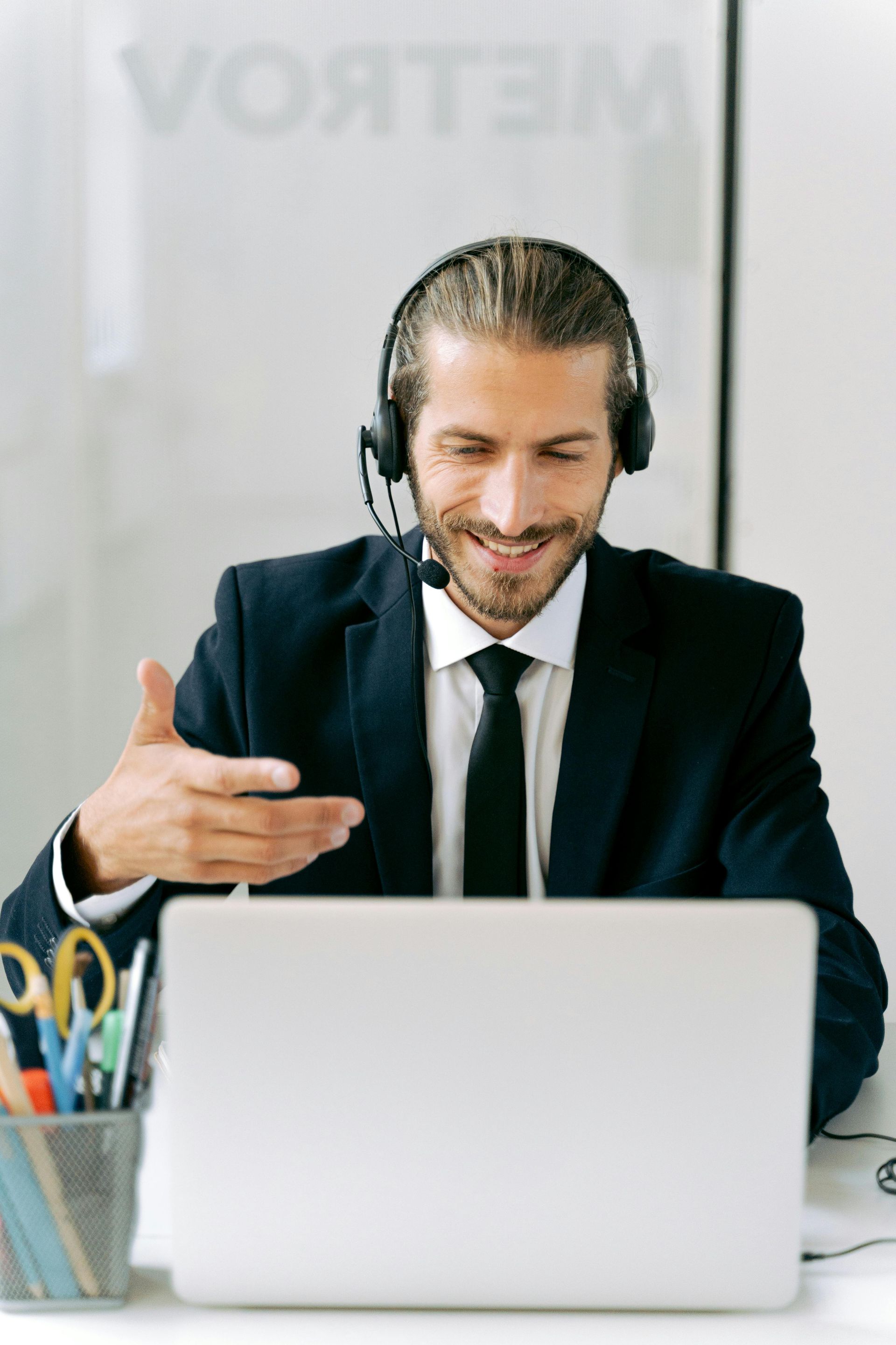 A man wearing headphones is sitting in front of a laptop computer.