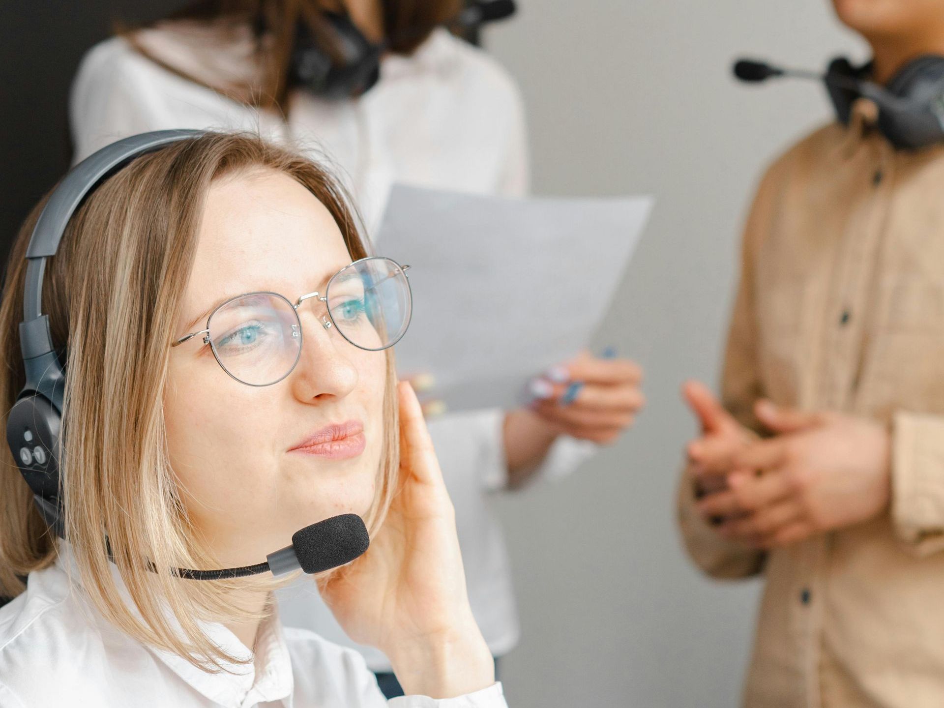 A woman wearing a headset is talking to a customer in a call center.