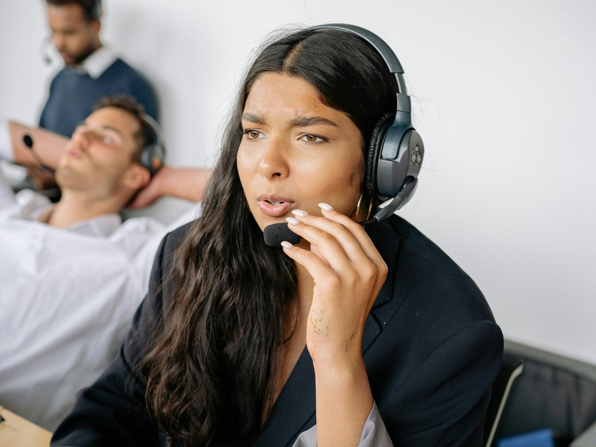 A woman wearing headphones is talking on a phone.