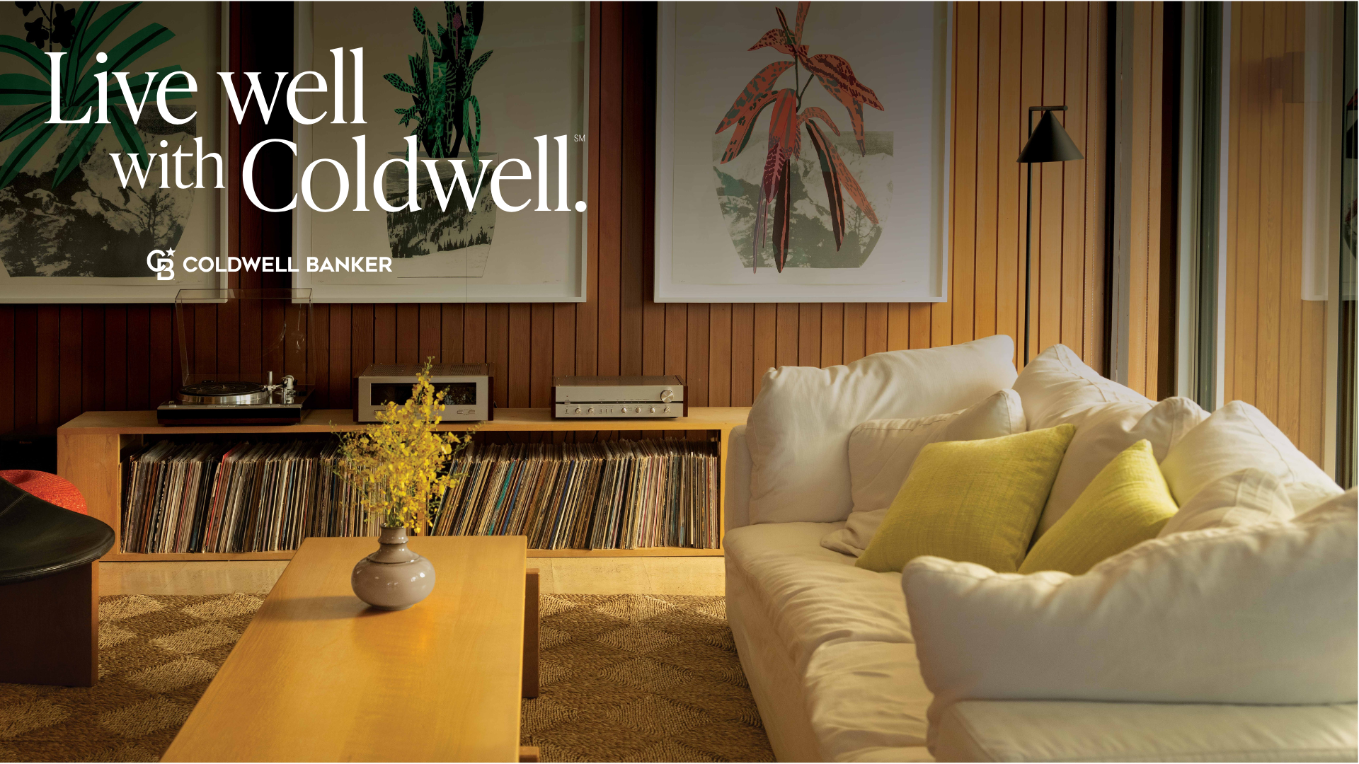 Living room with wood paneling, records, sofa, artwork, and the words 