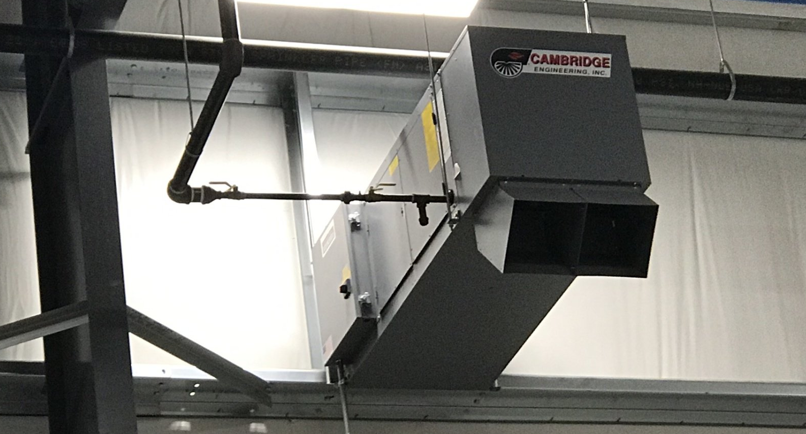 a large black box is hanging from the ceiling of a building .