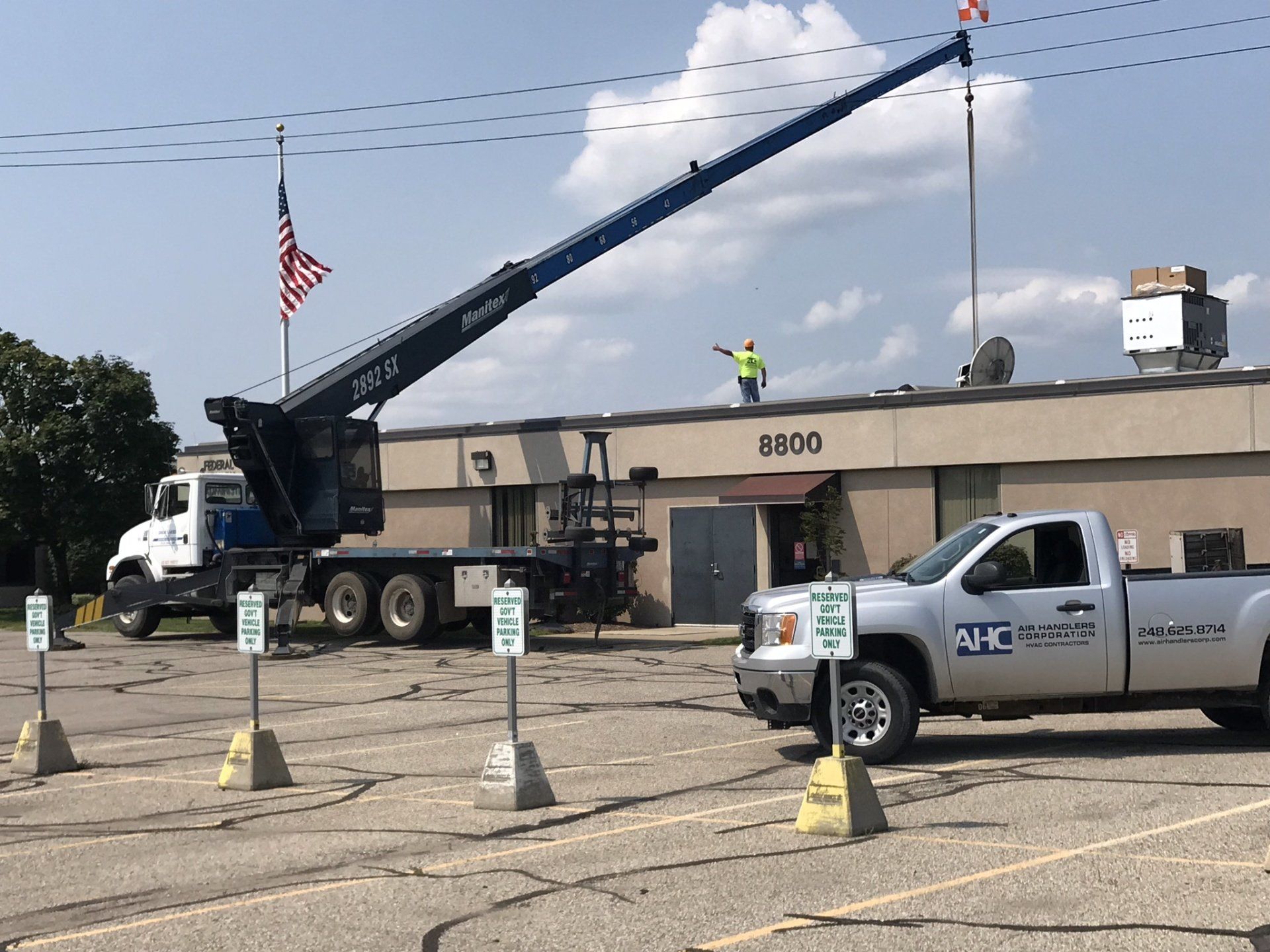 a truck is parked in front of a building with a crane on top of it .