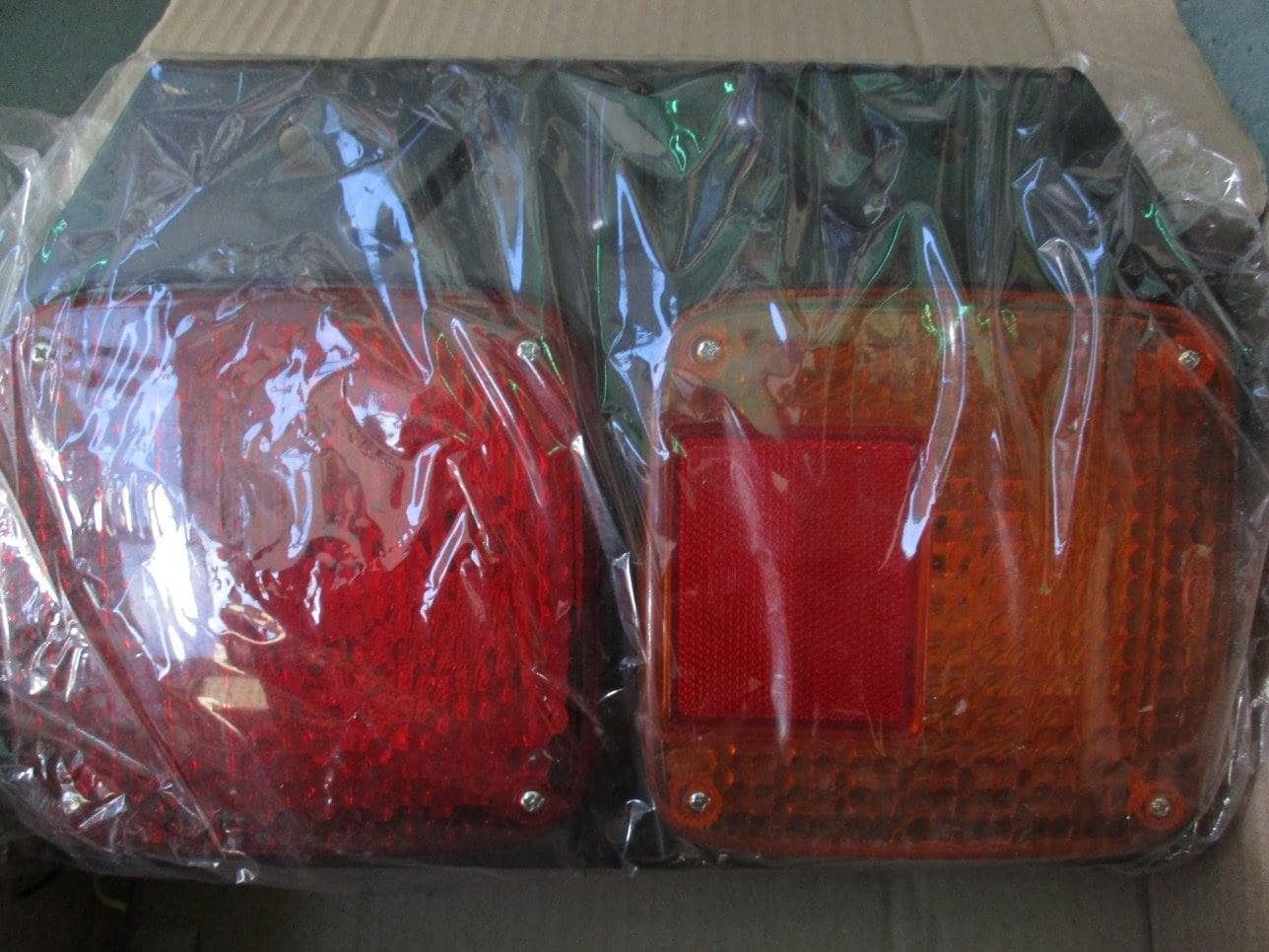 A Pair Of Tail Lights Are Wrapped In Plastic And Sitting On Top Of A Cardboard Box — Goulburn Automotive Centre In Goulburn, NSW