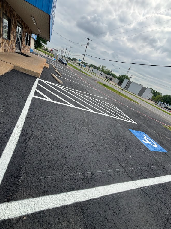 A handicapped parking spot is painted on the side of the road.