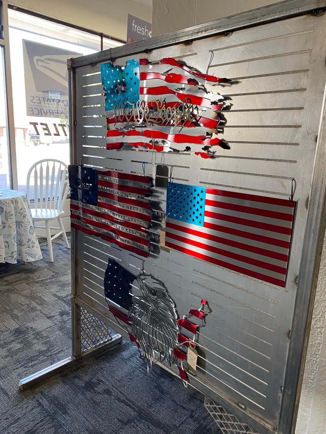 Metal display with several American flag artworks attached.