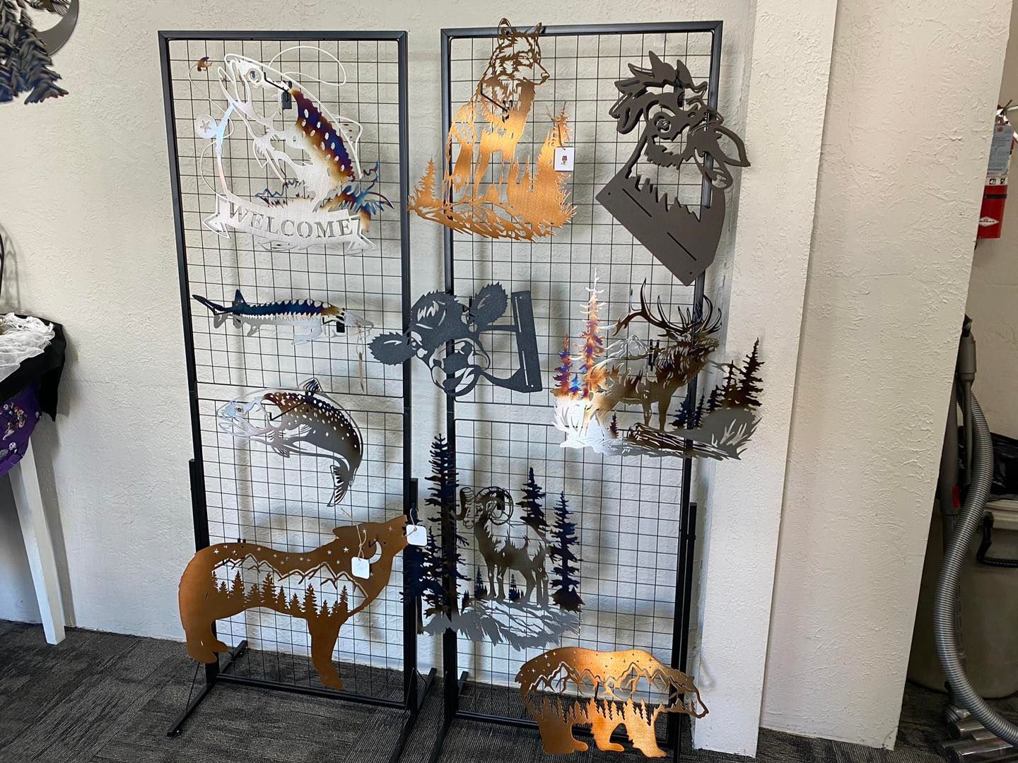 Metal art display with various animal and nature-themed silhouettes in a shop setting.