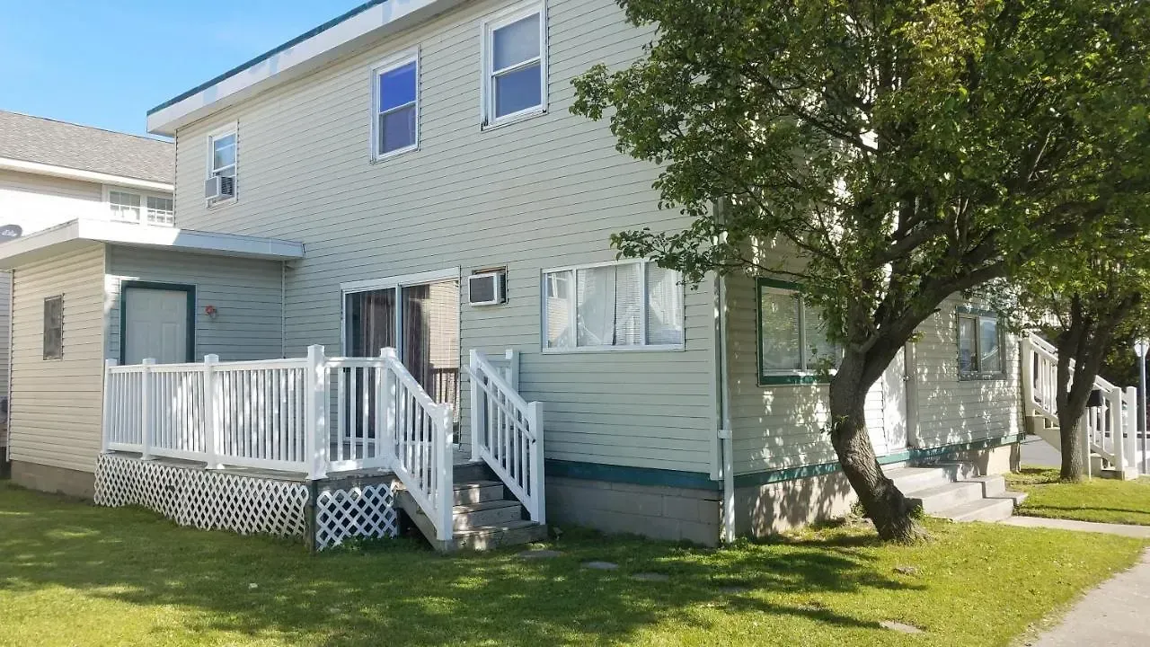 A white house with a white deck and stairs