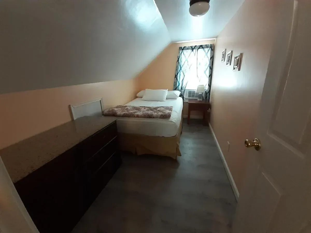 A bedroom with a single bed and a dresser