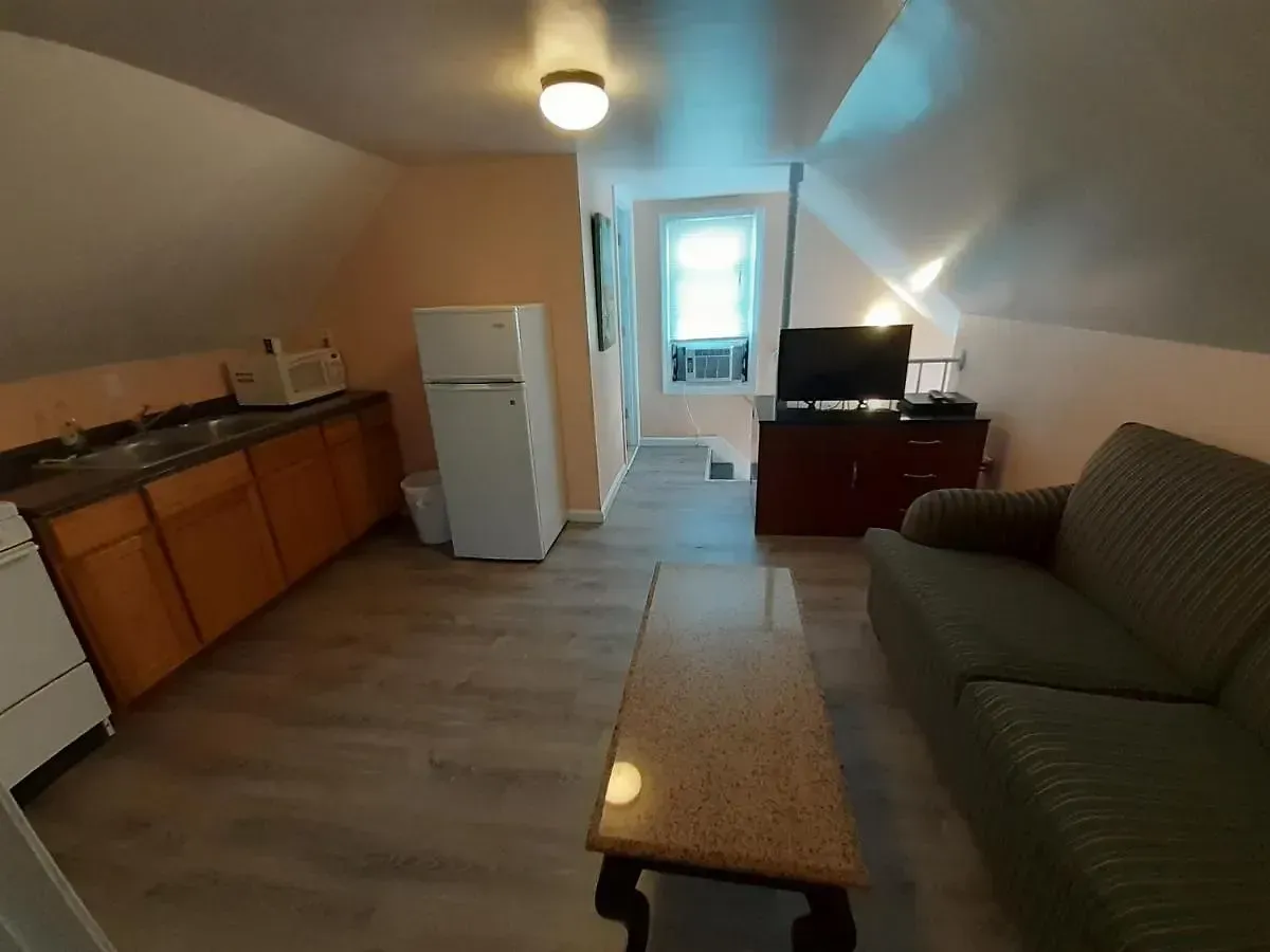 A living room with a couch a table and a refrigerator