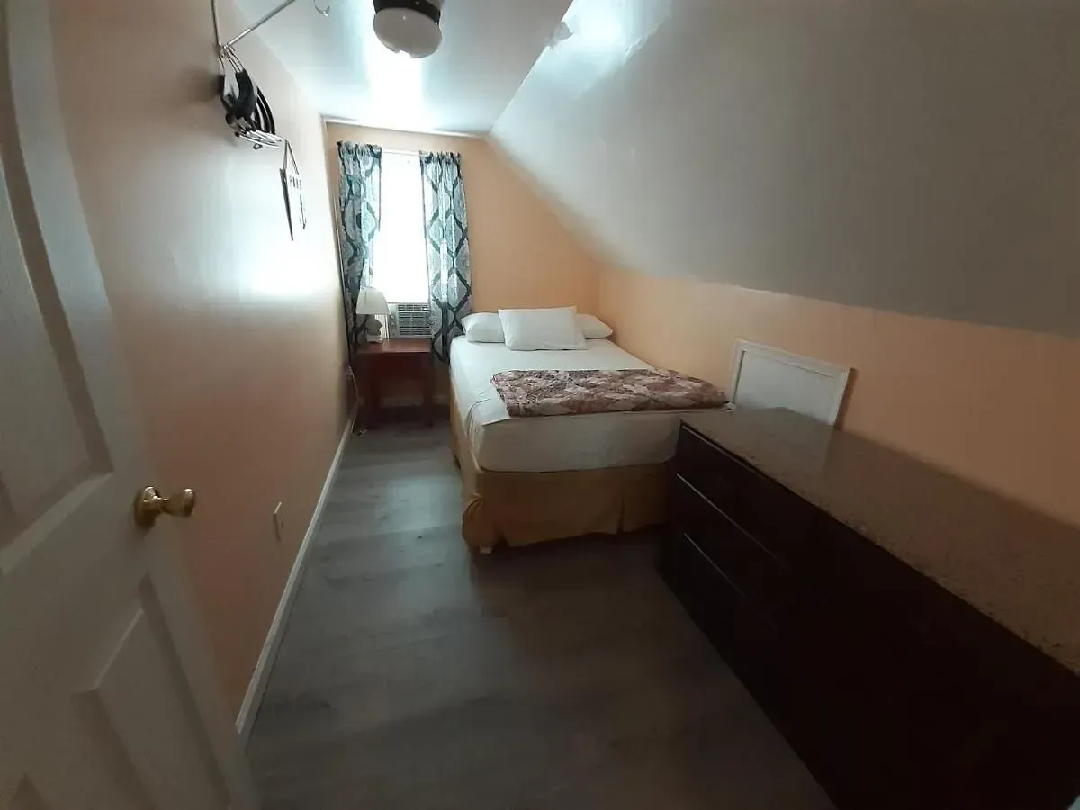 A small bedroom with a bed and a dresser